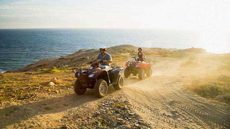 People riding on ATVs with ATV safety gear.