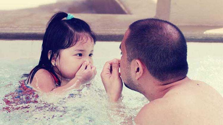 Dad practicing water safety with daughter.