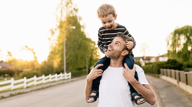 Dad carrying son on his shoulders.