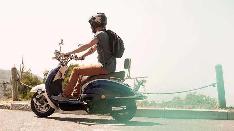 Man in helmet riding a scooter.