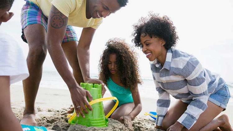 Family playing in the sand at the beach.