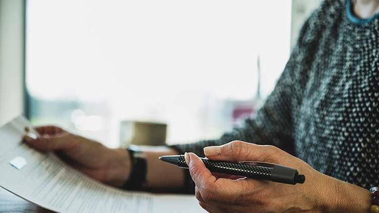 A woman with pen in hand reviews a will.