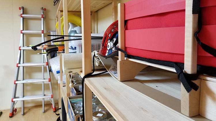 Basement showing items on shelves and items leaning against walls.